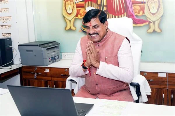 कार्यालय में लैपटॉप के सामने बैठे मुख्यमंत्री डॉ. मोहन यादव हाथ जोड़कर अभिवादन करते हुए